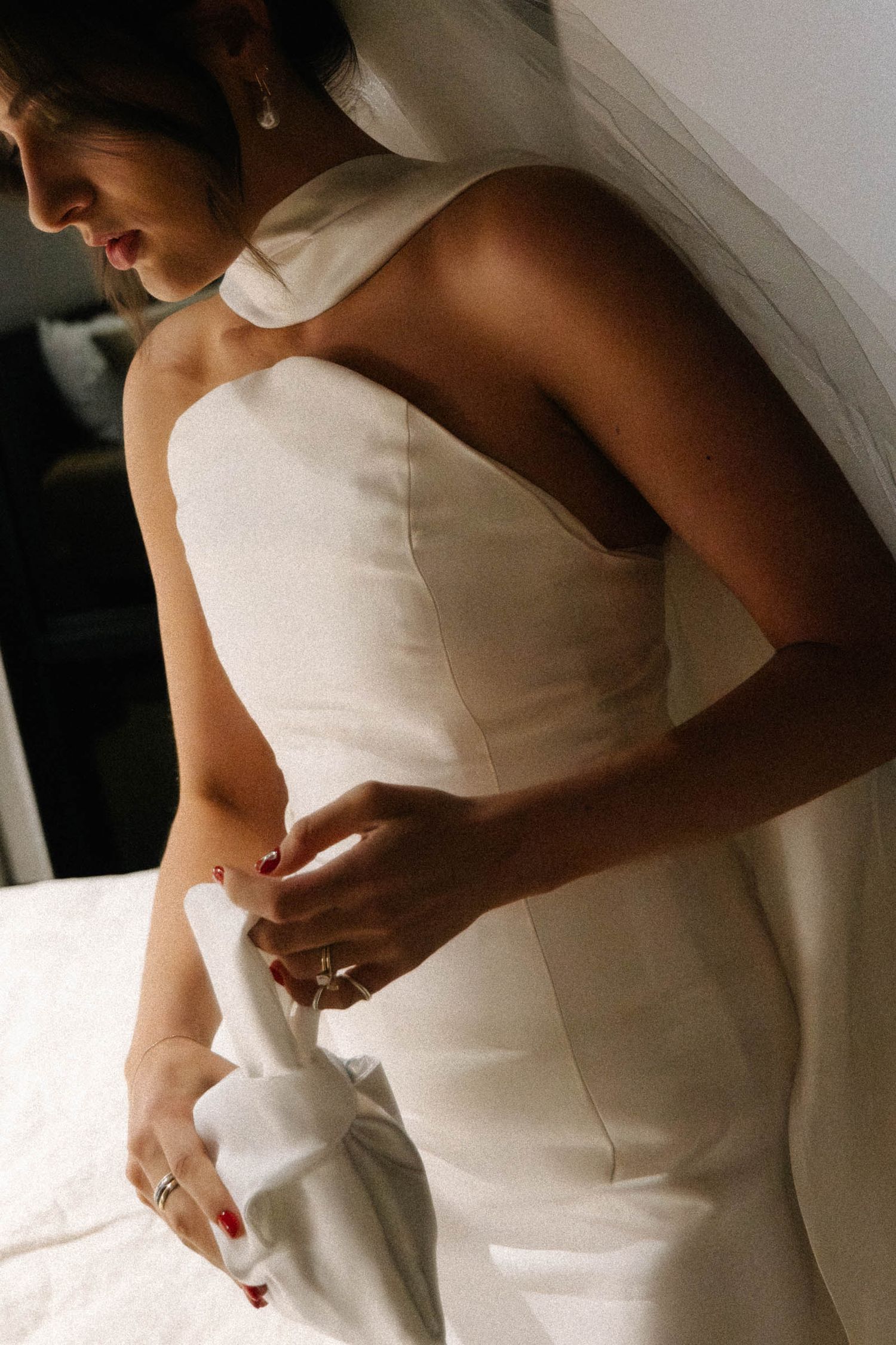 Close-up details of a white wedding dress being fitted and adjusted, showing elegant fabric draping and delicate details.