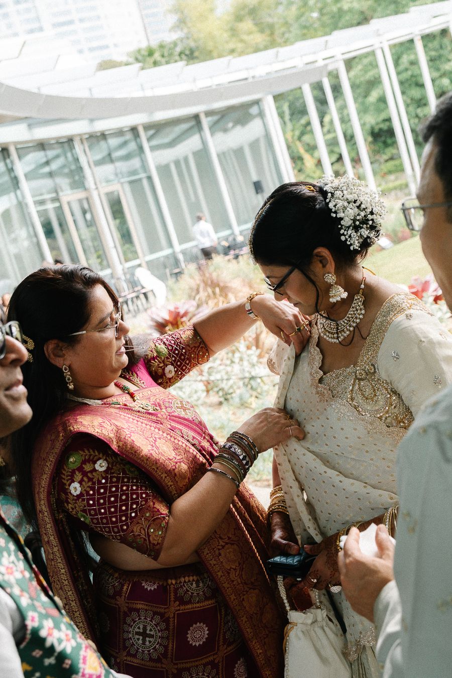 A series of candid moments showing guests embracing and celebrating at a traditional South Asian wedding reception.