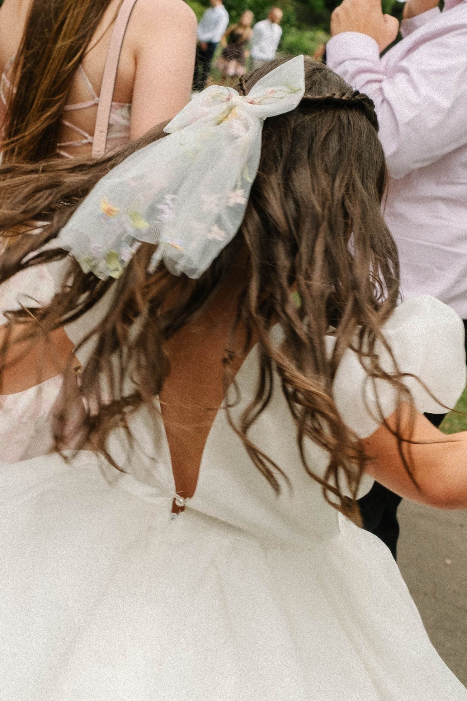 A close-up view of a wedding dress with delicate lace details and flowing fabric in white.