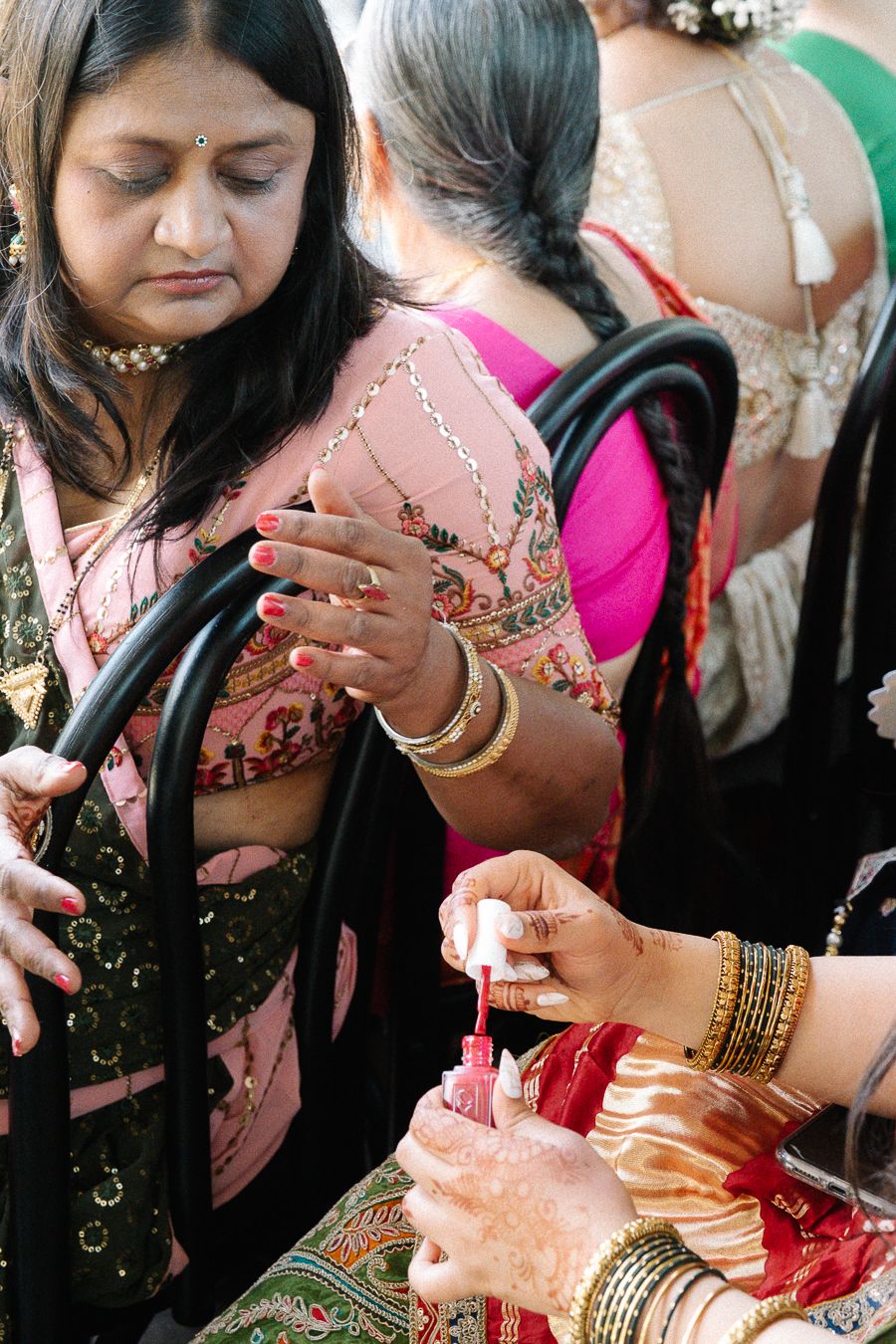Hands adorned with bangles and traditional jewelry participate in a cultural ceremony or ritual.