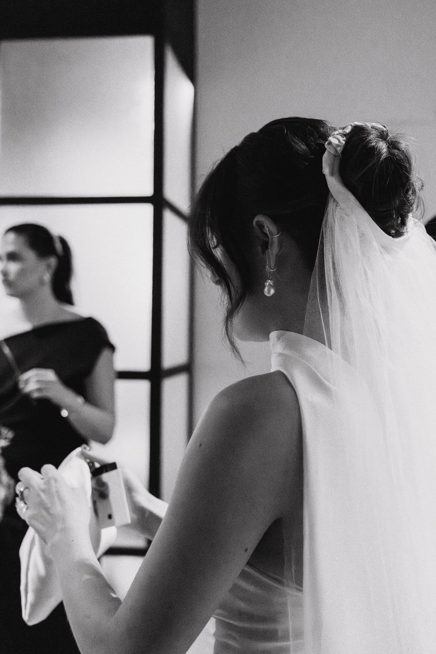 Black and white sequence of a bride getting ready for her wedding day, showing delicate preparation moments.