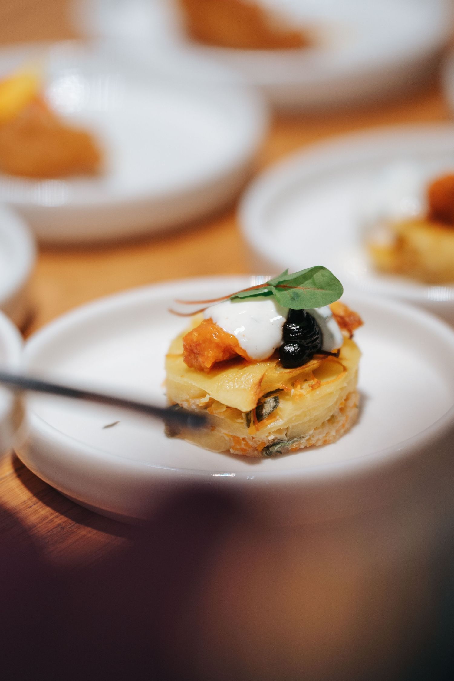 Close-up sequence of appetizer bites with olives and garnish on white plates showing progressive focus shifts.