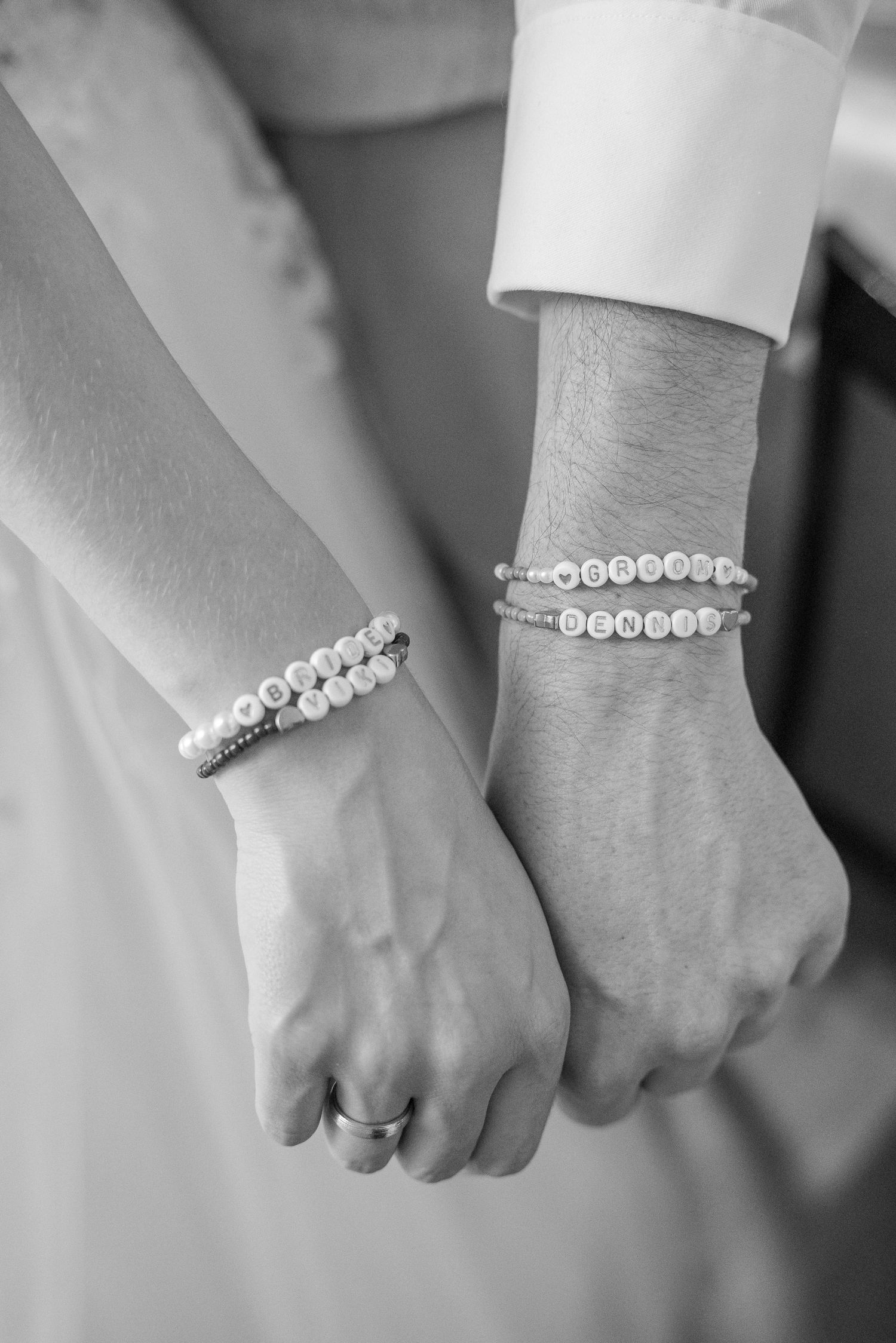 Black and white close-up photos showing hands wearing delicate beaded bracelets and rings.