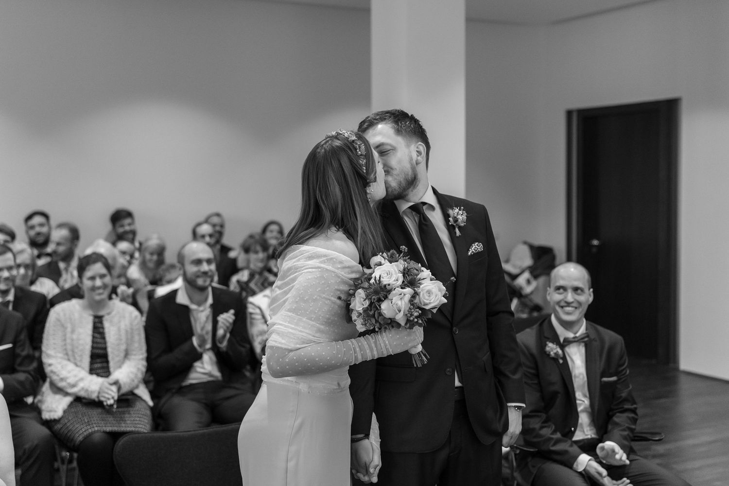 A sequence of black and white wedding reception photos showing guests dancing and celebrating at a formal event.