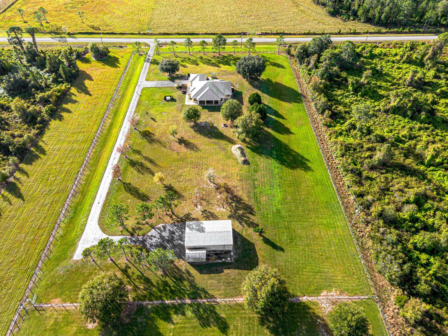 A drone photo of a house with land for sale.