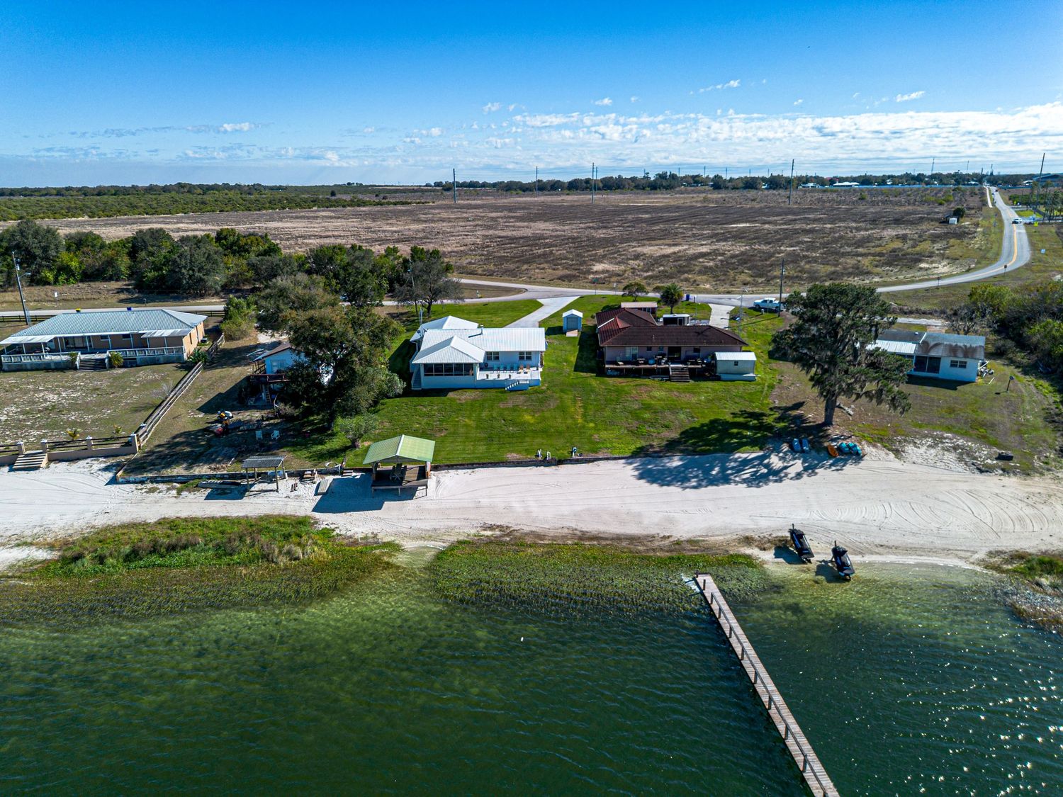A drone photo of a house for sale on a lake.