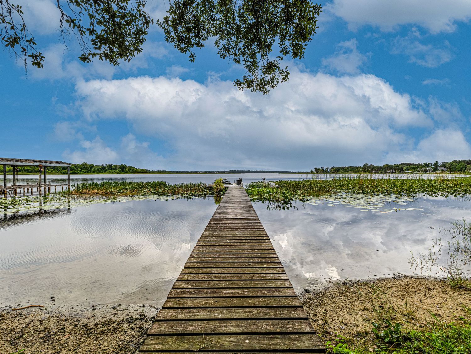 A photo of a dock that enters a lake for a house that is for sale.