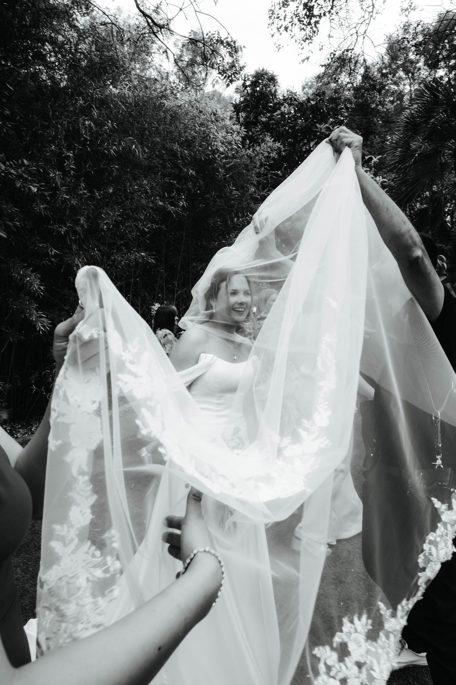 Black and white artistic wedding photo of bride smiling through cathedral veil, Barcelona