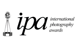 International Photography Awards (IPA) logo with trophy icon and elegant black italic typography on white background.