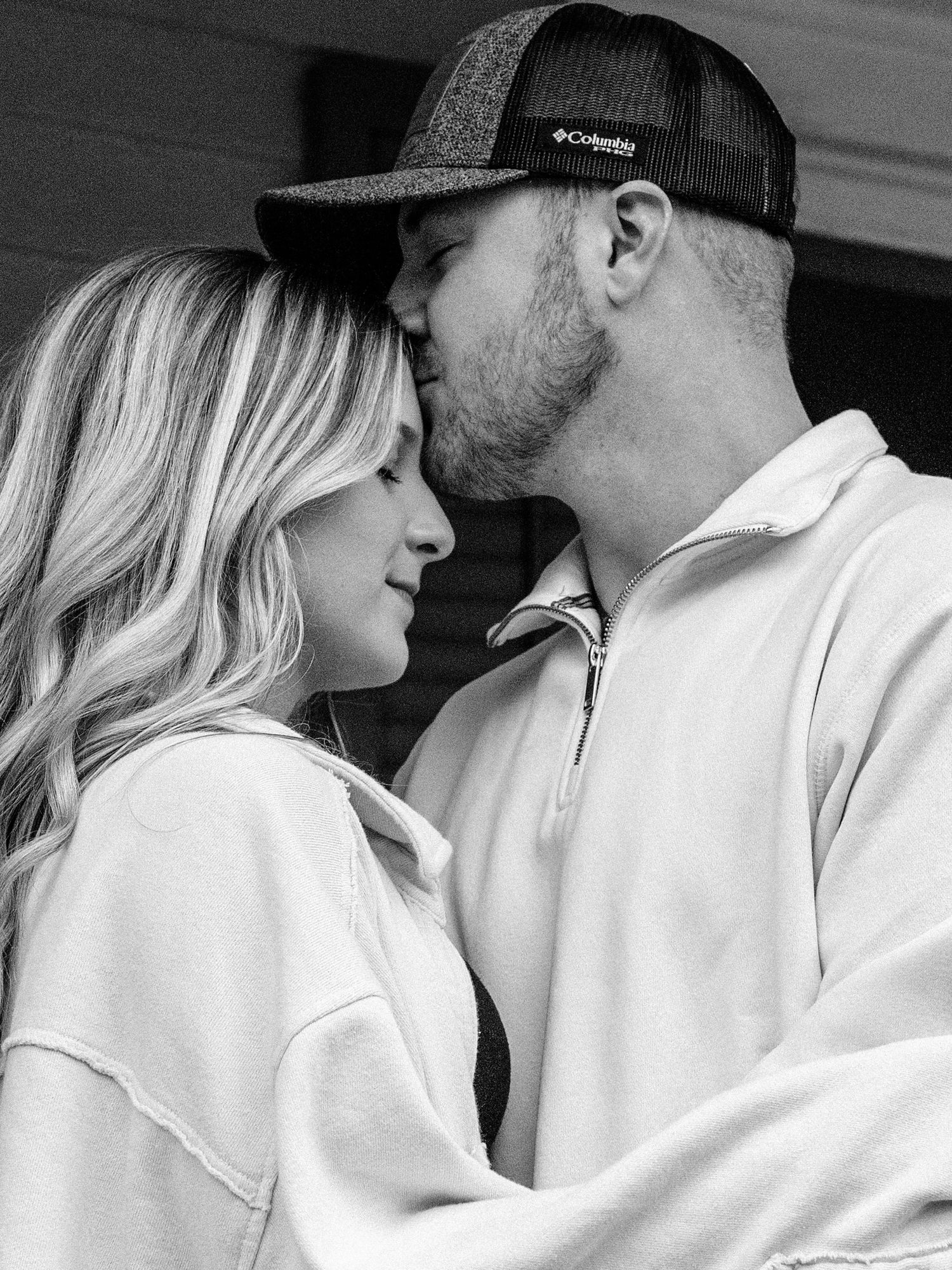 Man kissing woman on the forehead in Downtown Dandridge, TN during couples photo session by Jefferson County Tennessee photographer