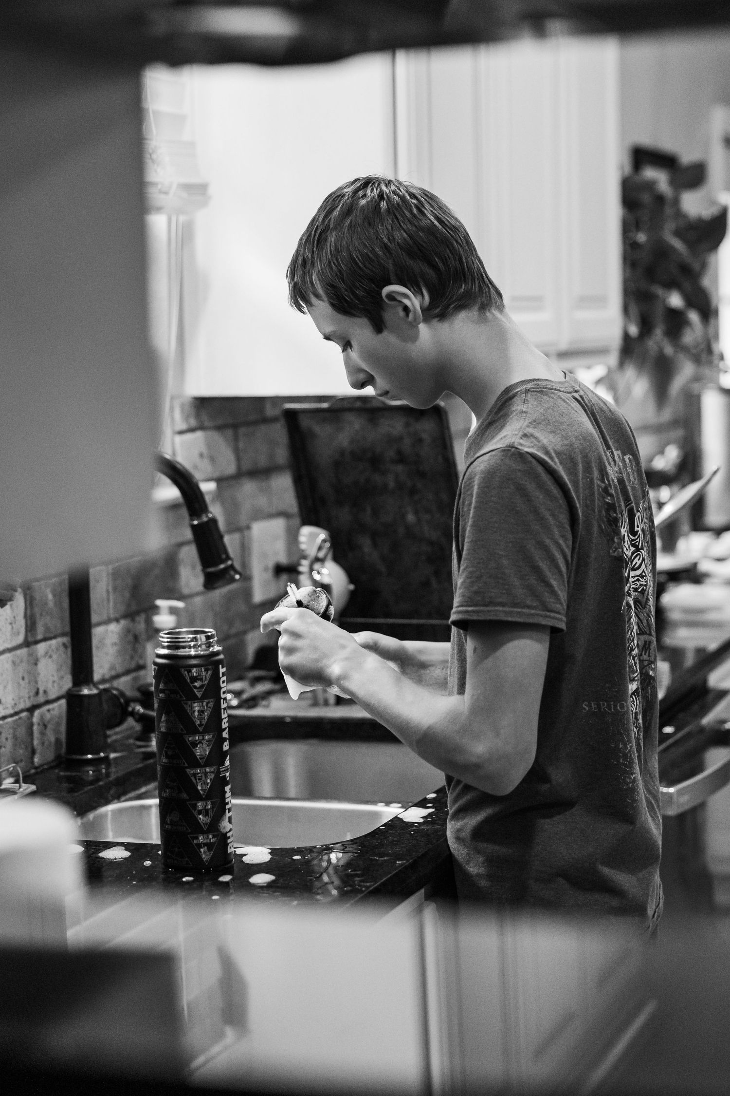 black and white images of a boy washing dishes