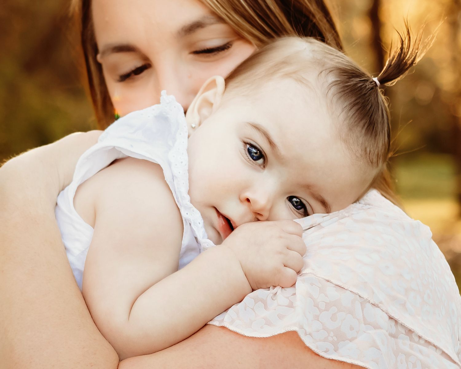 A soft, intimate close-up photo showing tender moments with a mother and her baby snuggling in Colleyville, TX family photos.