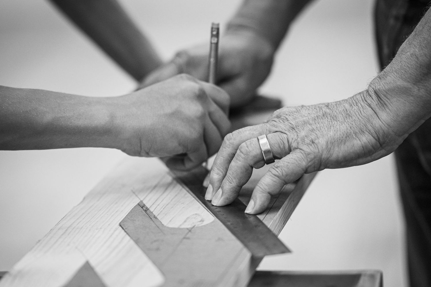 Close-up view of two hands making measurements on a woodworking project