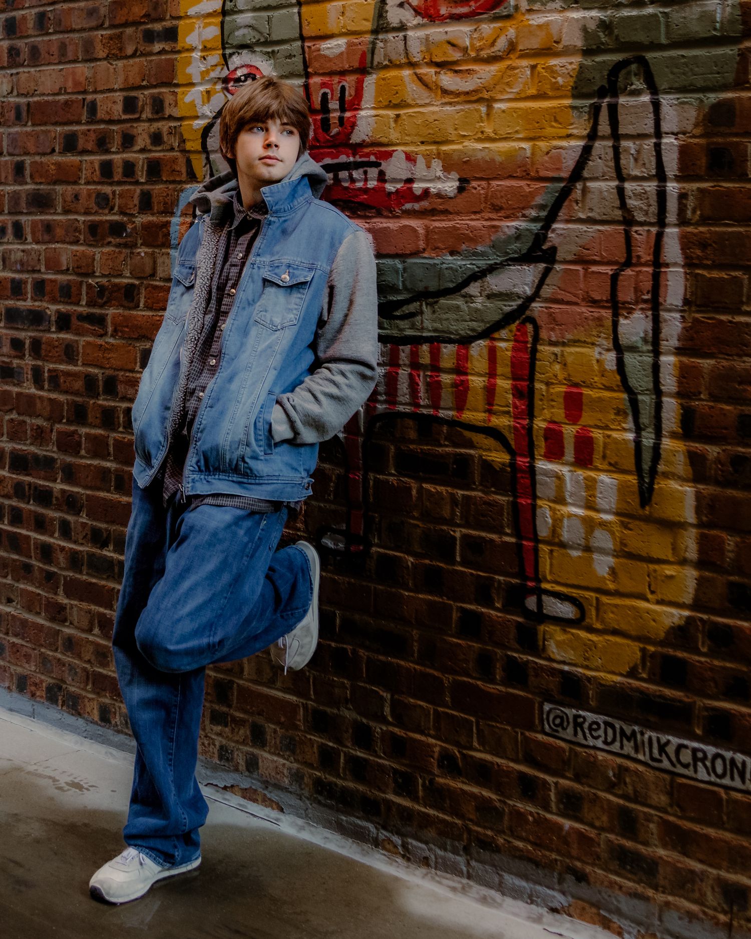 boy leans against brick wall during Senior Portrait session in Downtown Fort Worth, Scat Jazz Alley