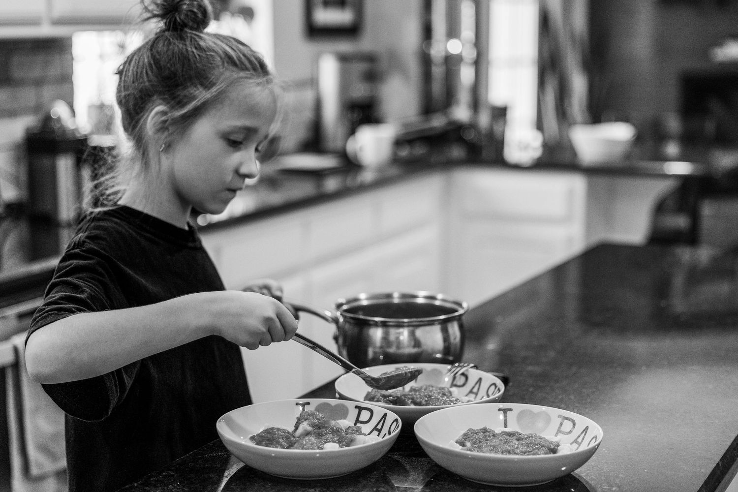 black and white images of a girl dishing up pasta