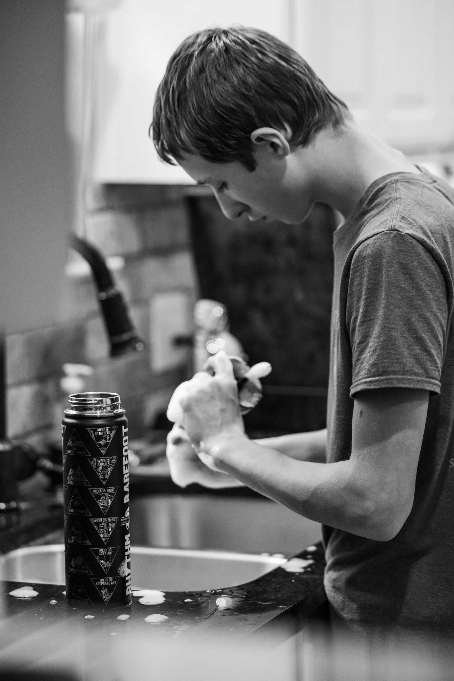 black and white images of a boy washing dishes