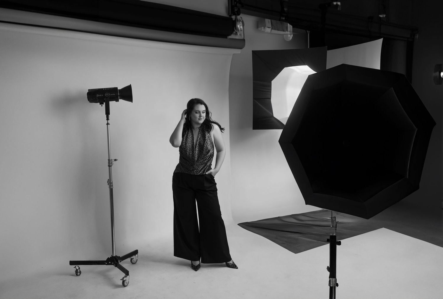 Professional photography studio setup with lighting equipment and a dark backdrop.