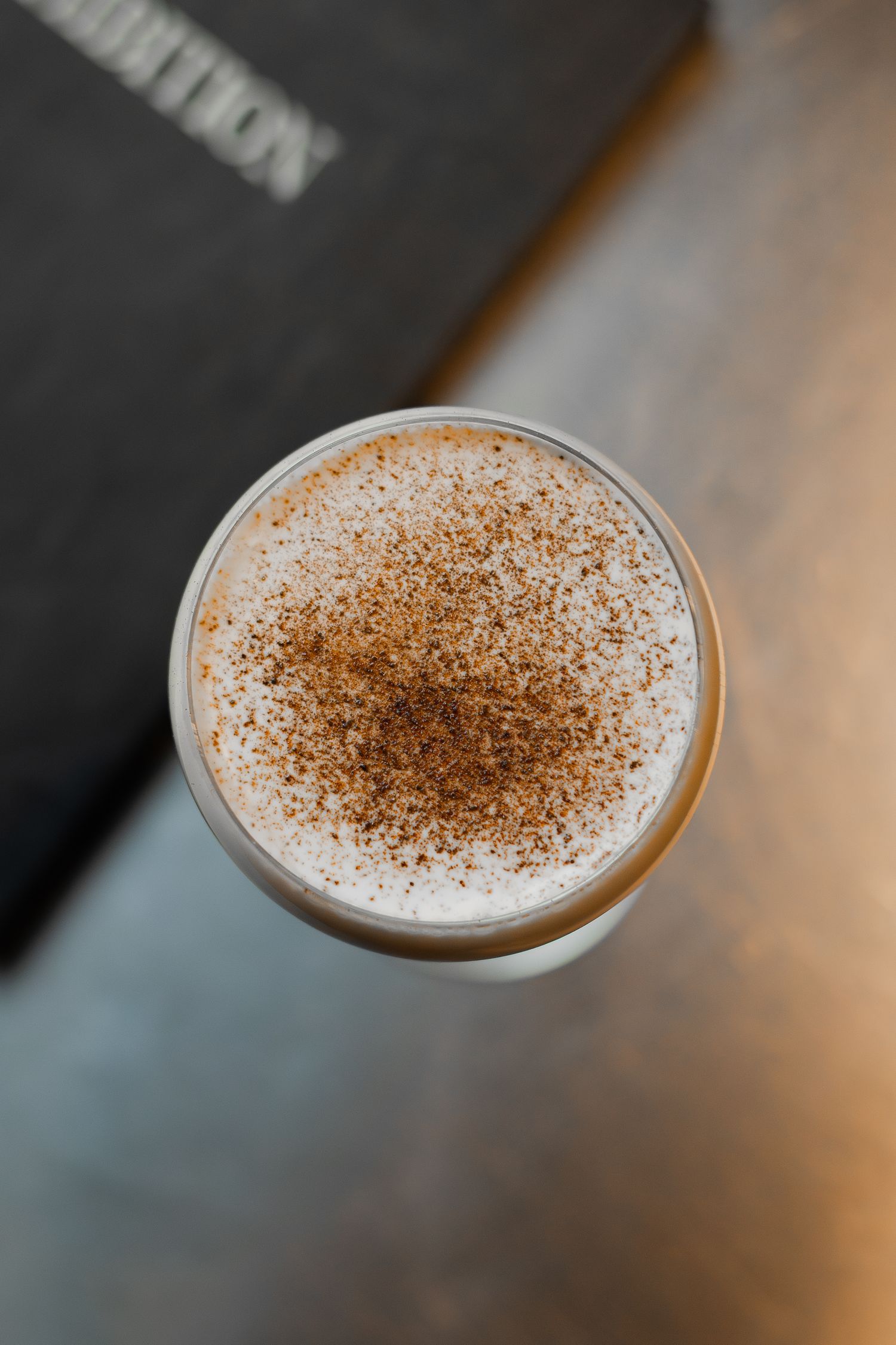 Overhead view of frothy coffee drink with cocoa powder dusting on top.