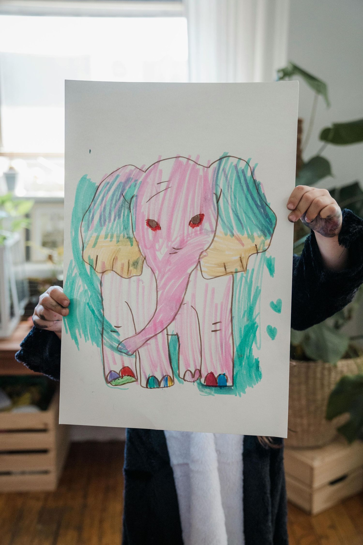 Boy proudly holding up animal drawing artwork in his Watkins Glen, NY home