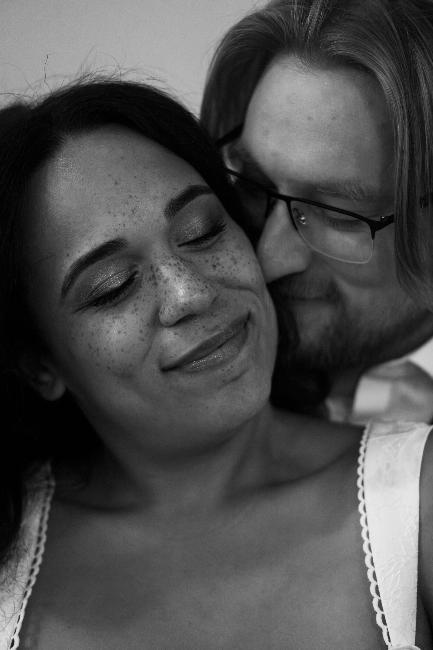 black and white Couple cuddling outside the Palace Movie Theater in Corning, NY during a winter wedding engagement photo session
