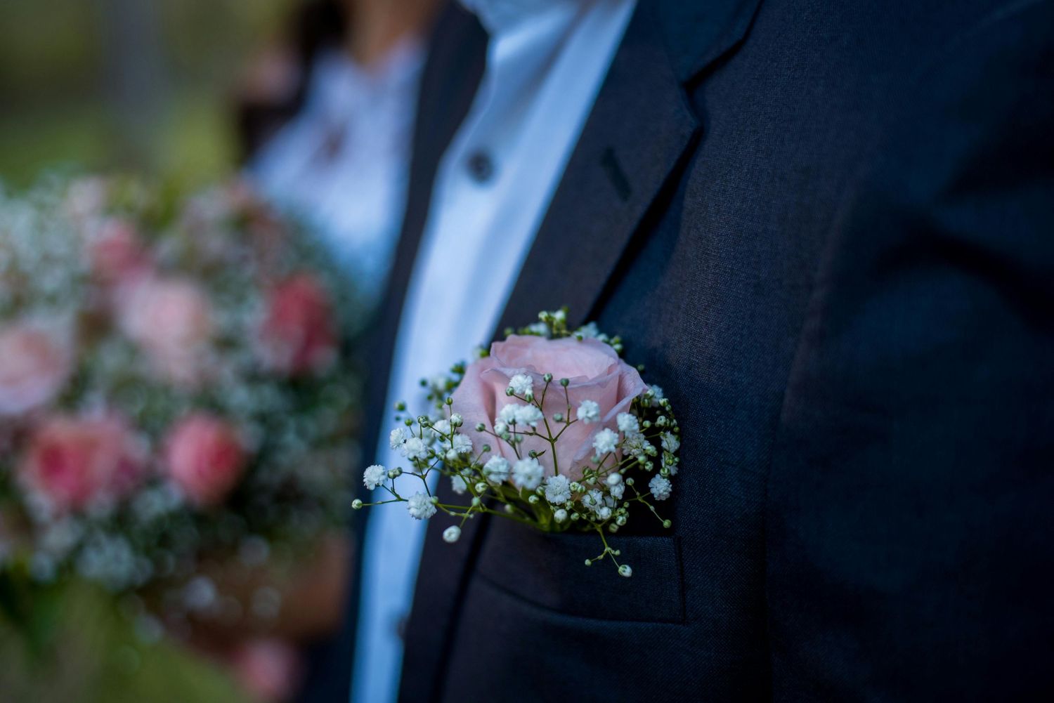 Groom in navy suit holding boutonniere during wedding vow renewal in Horseheads, NY