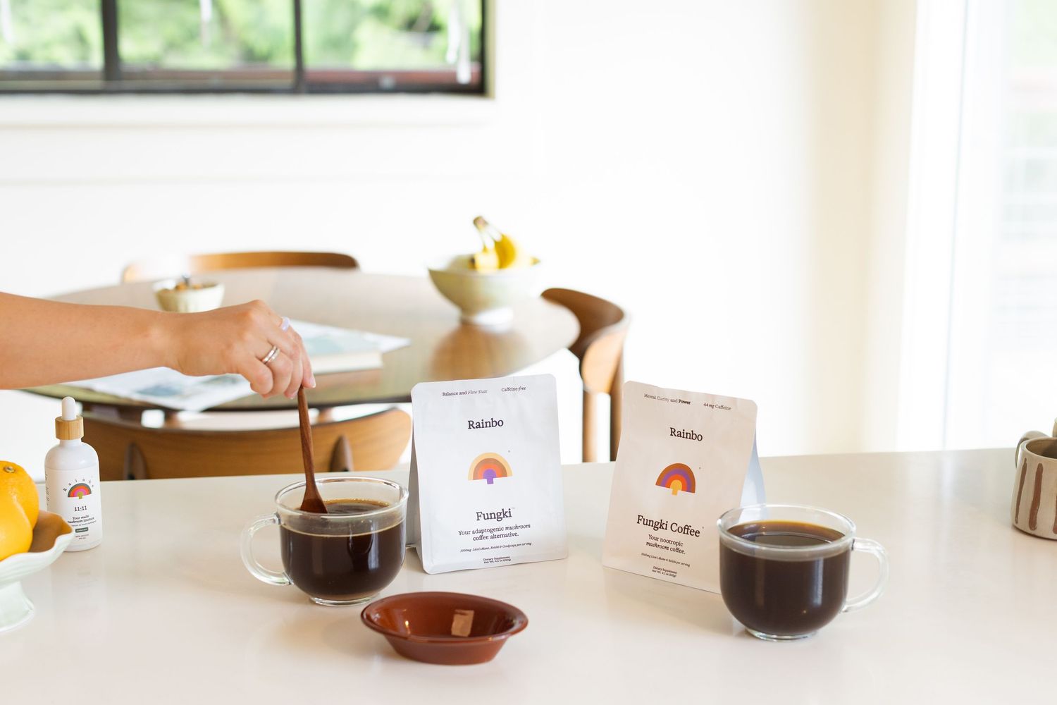 Two glass cups of black coffee with Pangia Coffee packets displayed on a white table.