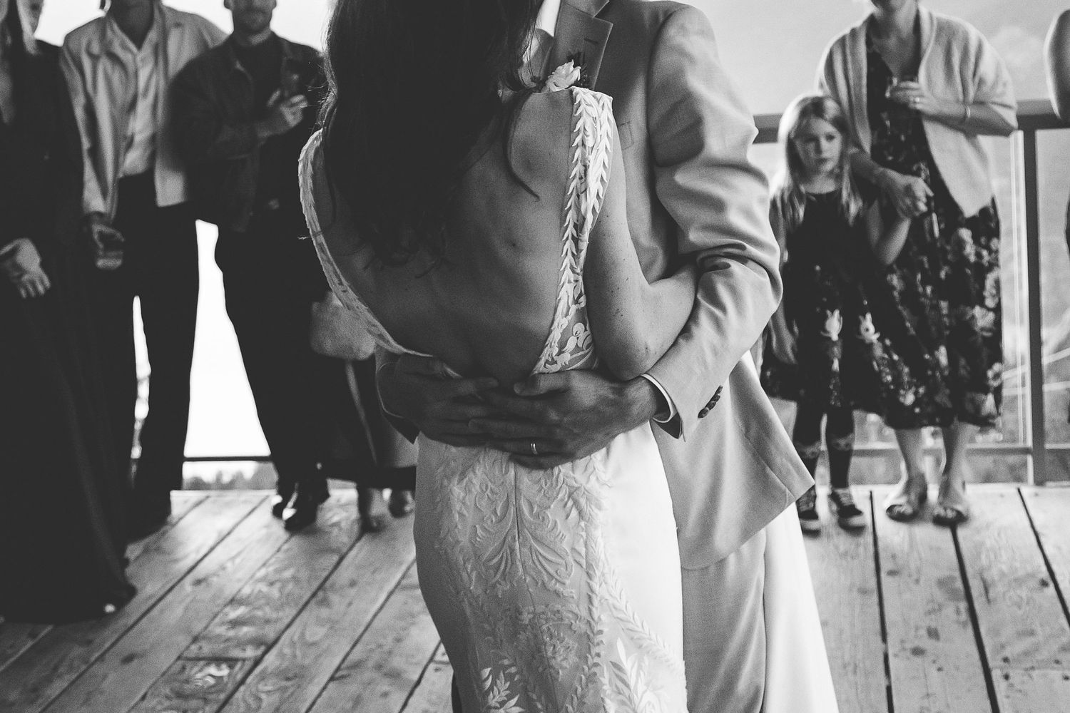 Intimate black and white photo of bride and groom embracing during first dance at wedding reception.