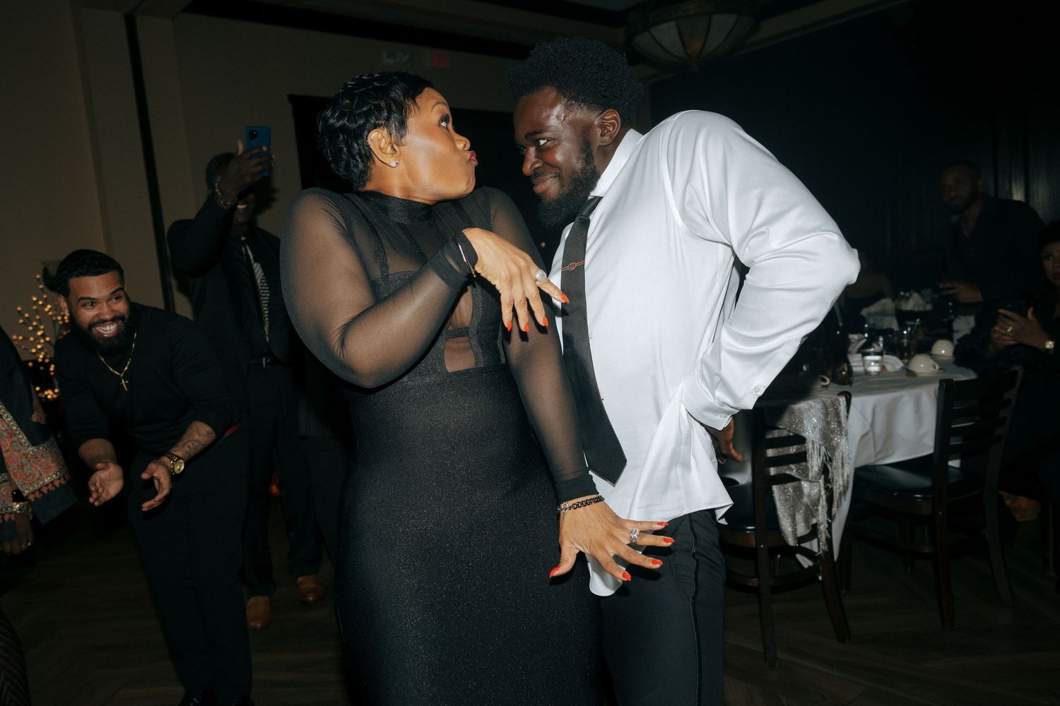 Two guests share a joyful dance moment at an elegant evening reception celebration.