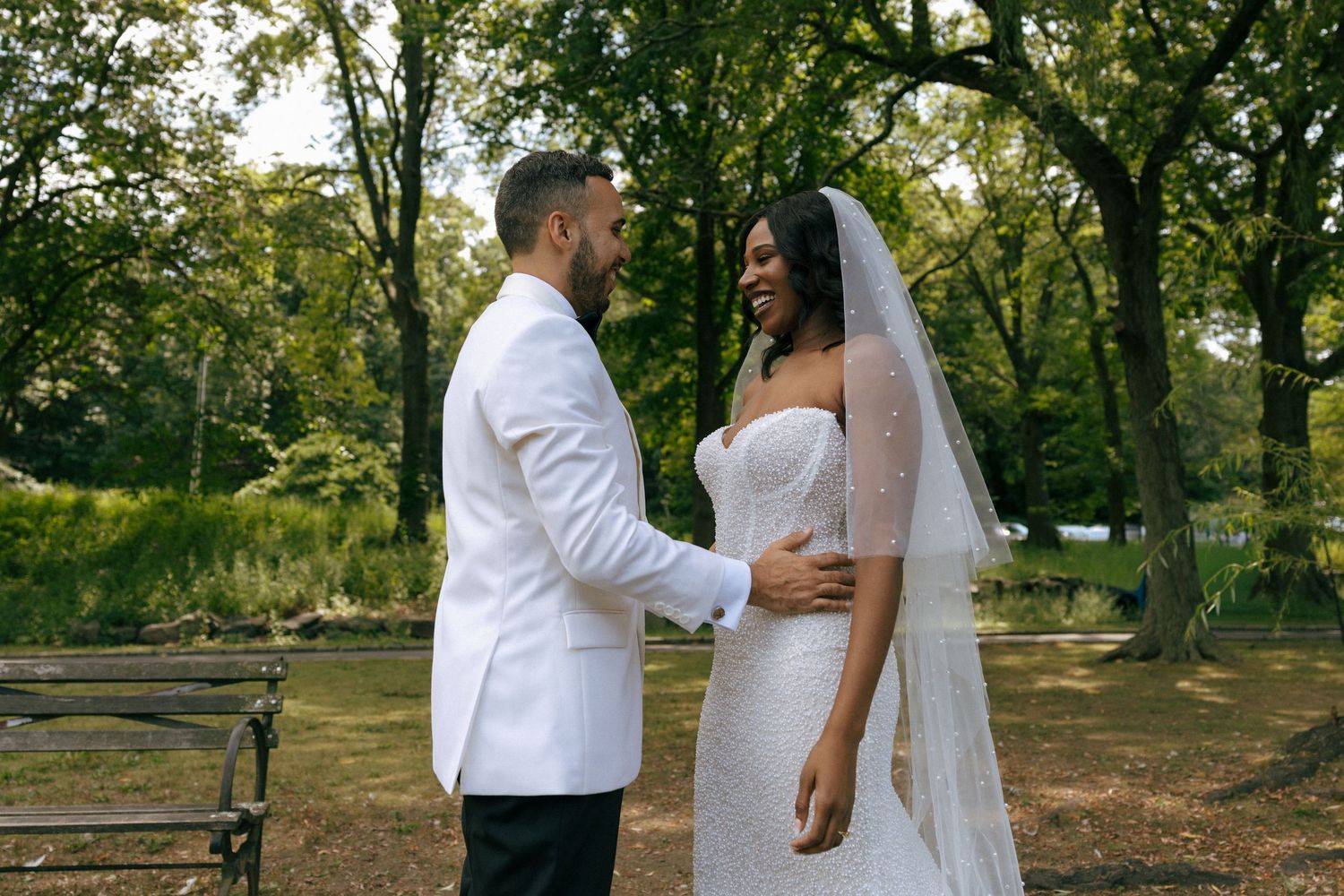 A bride and groom share a romantic moment in Central Park on their wedding day.