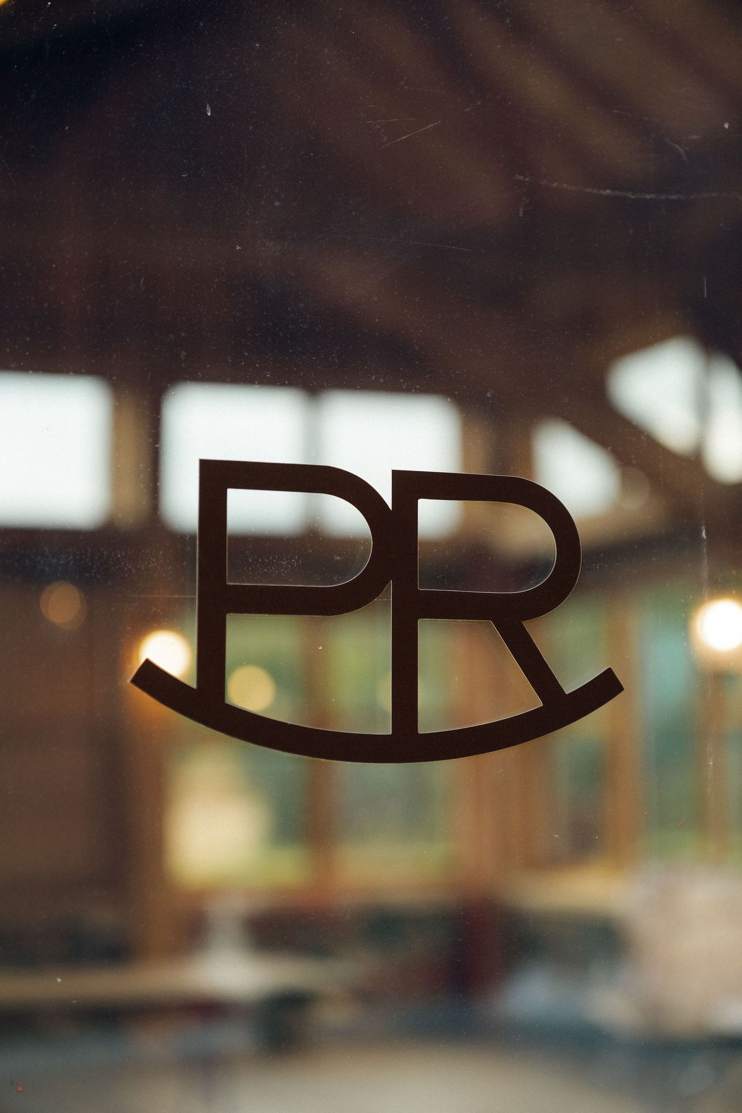 Modern typography signage with blurred interior background in warm lighting.