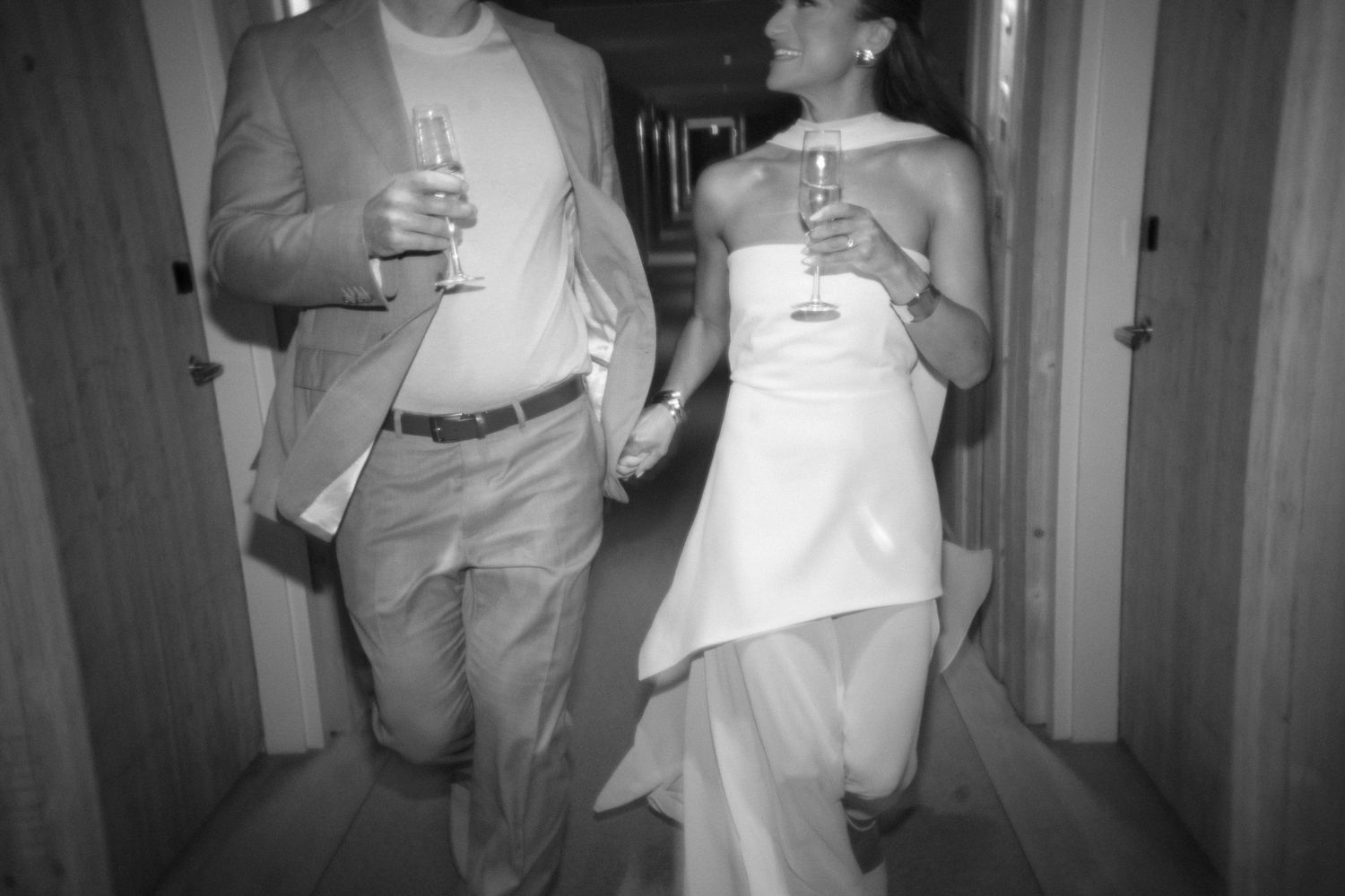 Wedding guests mingling and chatting in an indoor reception hallway.