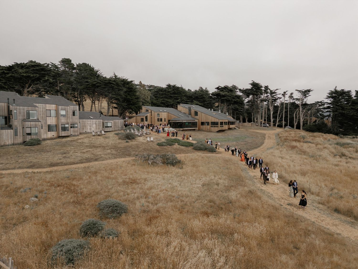 Panoramic view of guests walking along a coastal hillside path.
