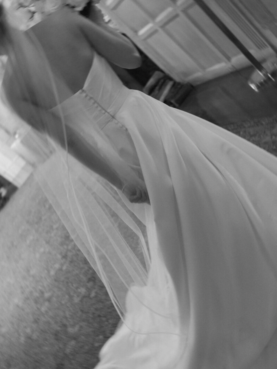 Close-up details of flowing white wedding dress fabric in black and white.