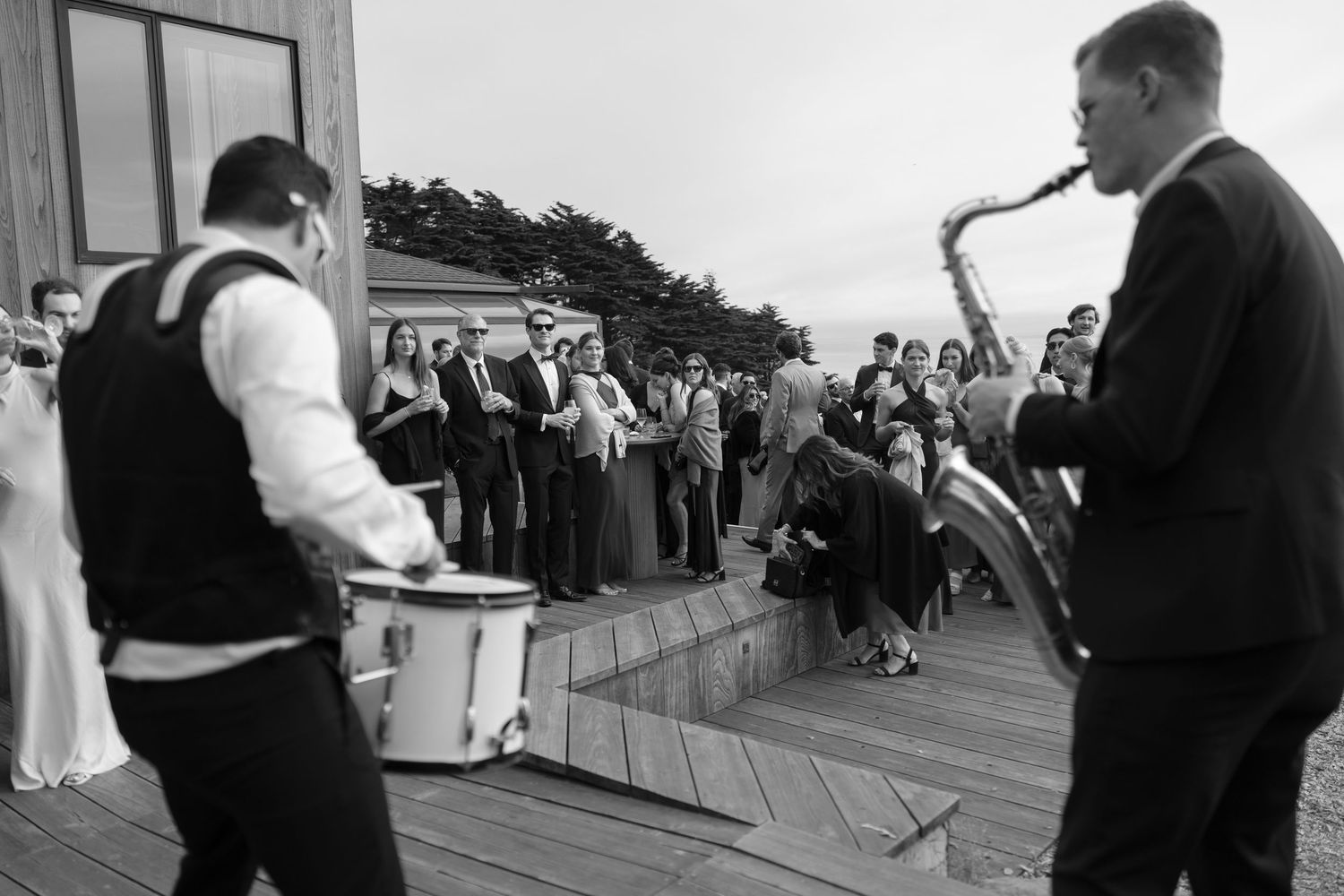 Wedding celebration on an outdoor deck with guests gathered.