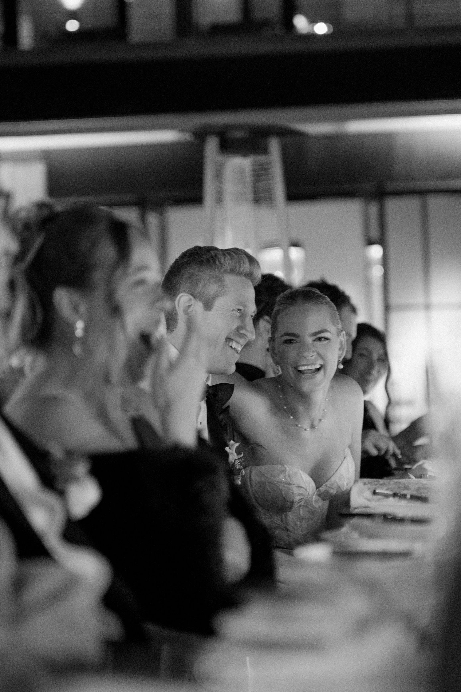 Wedding guests enjoying a candid moment of laughter at a reception.