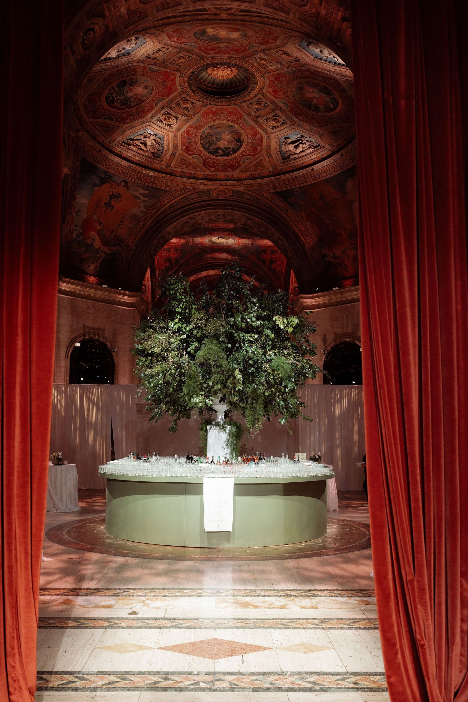 A grand, ornate interior with a large, lush floral arrangement in the center.