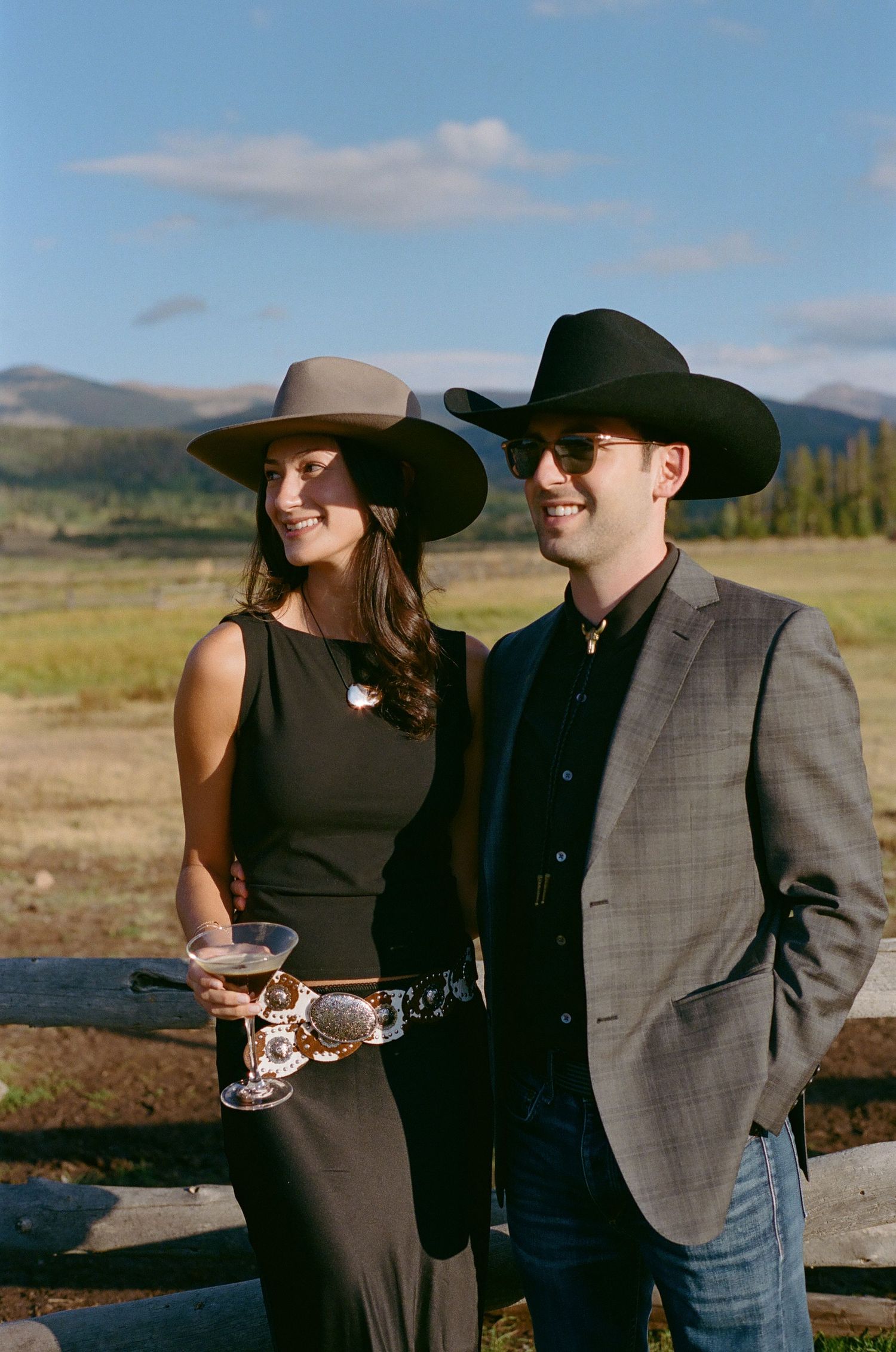 Guests mingling at an outdoor cocktail reception with cowboy hats and western attire.