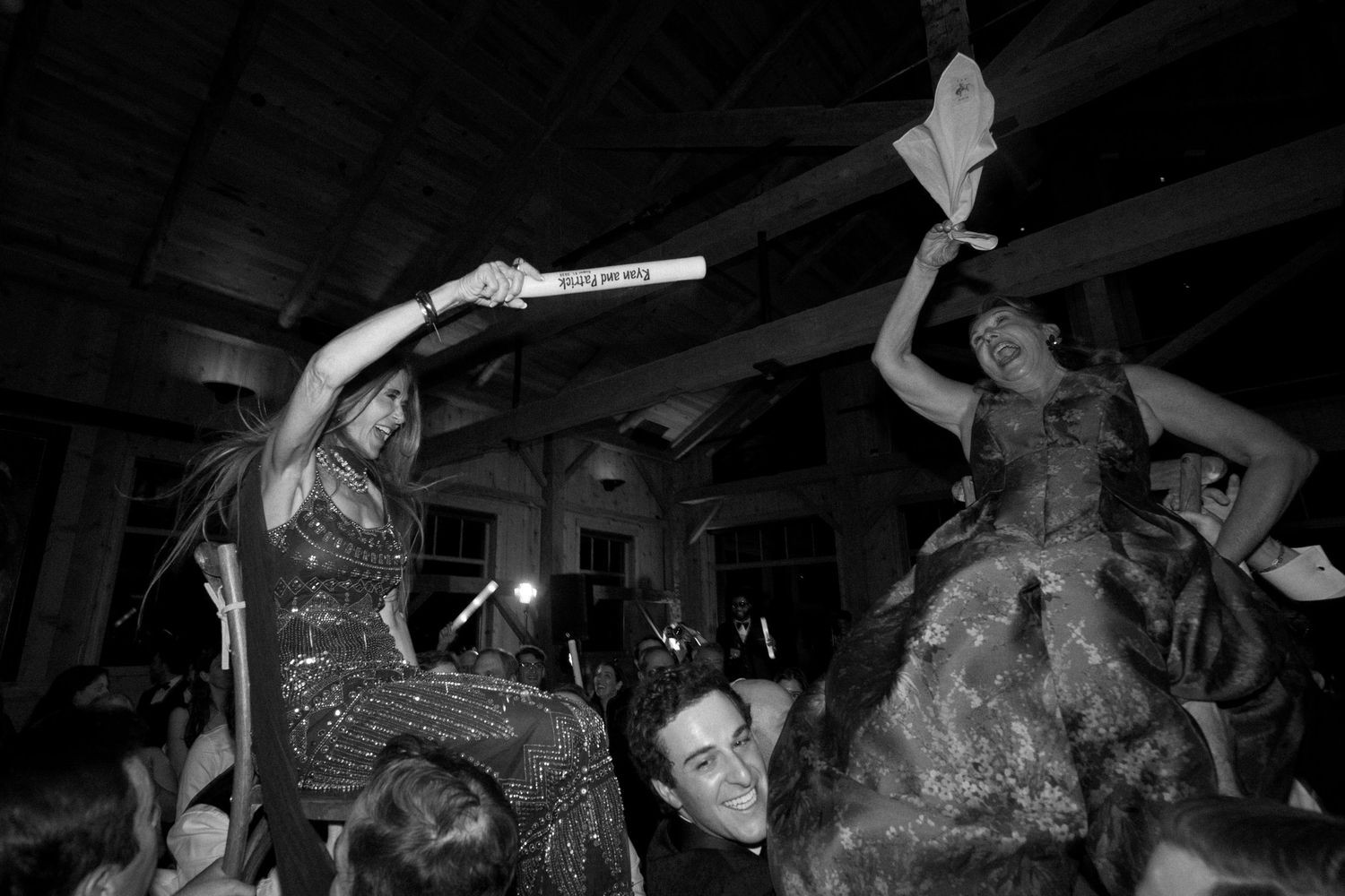 Wedding reception dance party with guests celebrating in a dark venue.