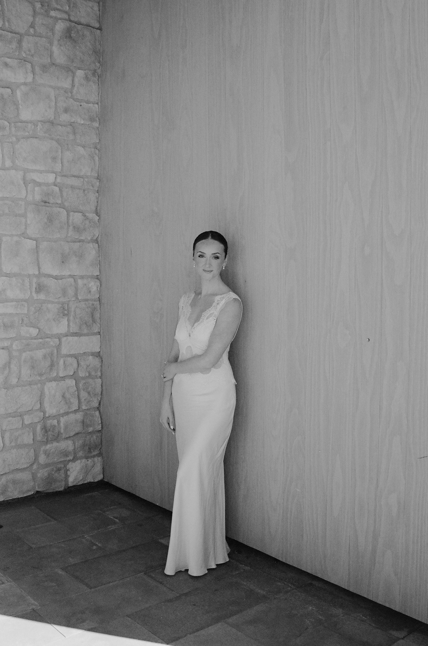 Artistic black and white portraits of a bride against a stone wall.