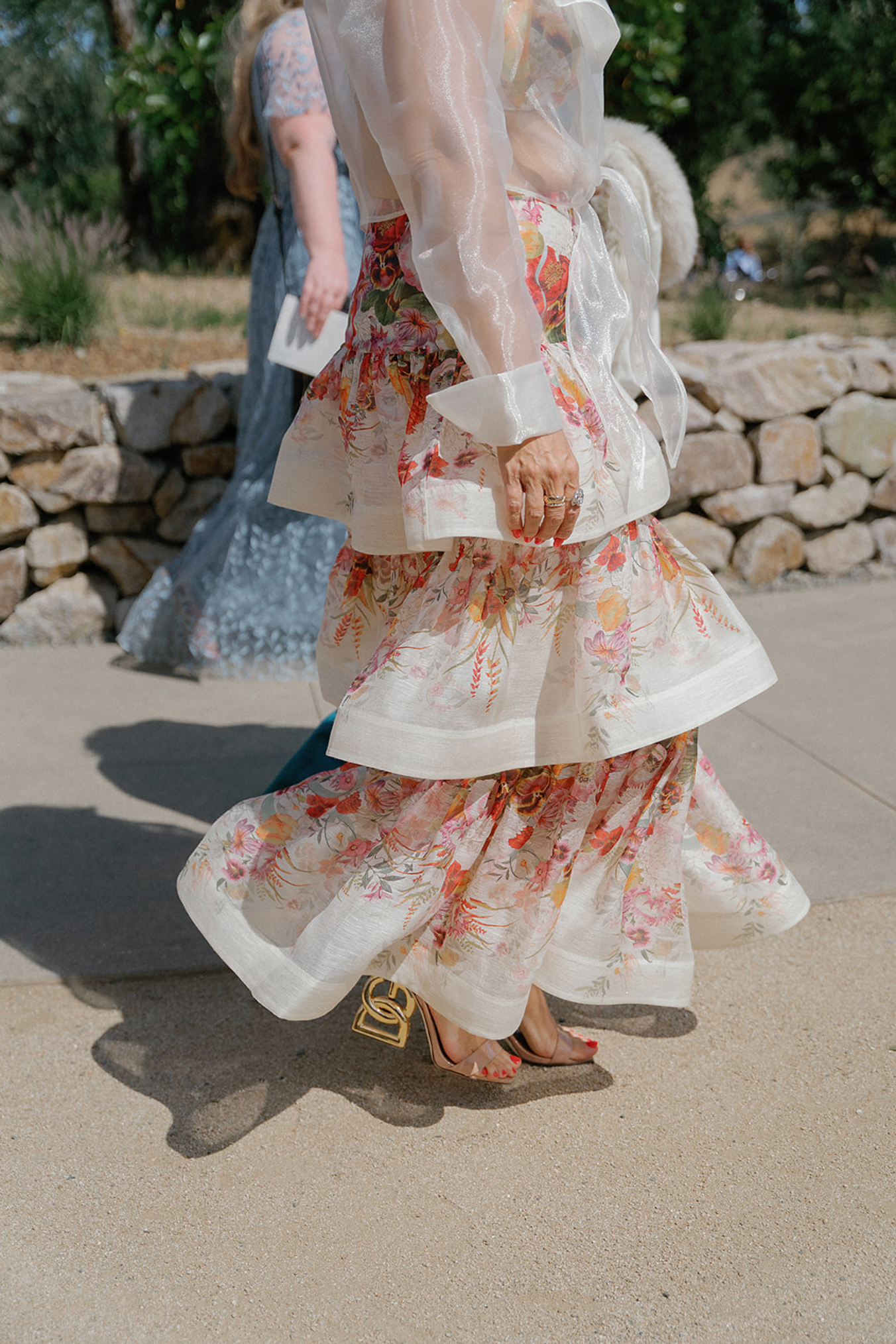 Close-up view of floral dress details and movement during a wedding celebration.
