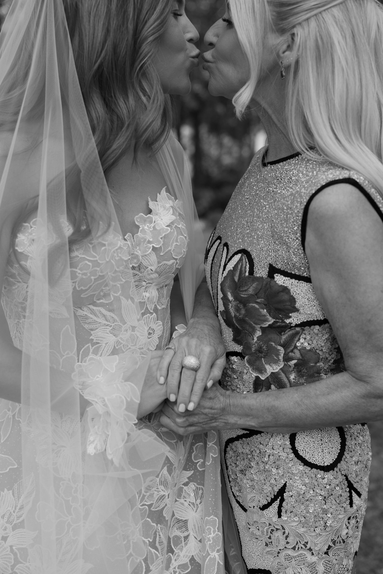 A black and white close-up of an intimate moment between two people at a wedding.