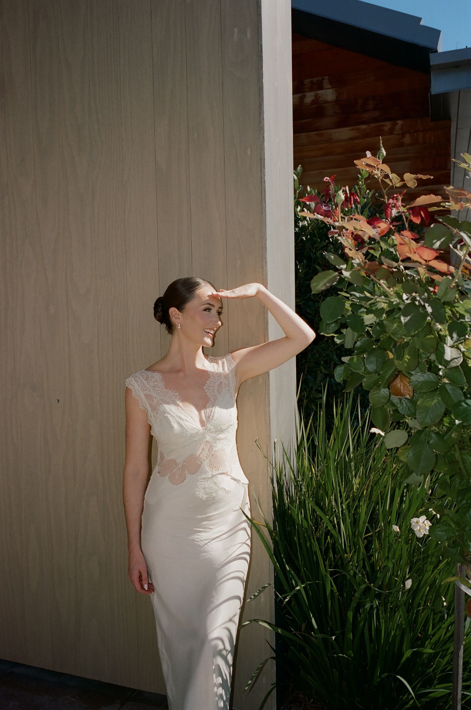 White wedding dress photographed in garden setting with natural lighting.