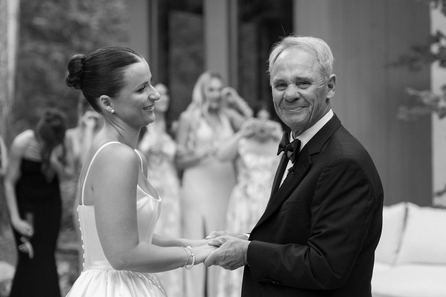 Black and white candid moments captured during an emotional wedding dance.