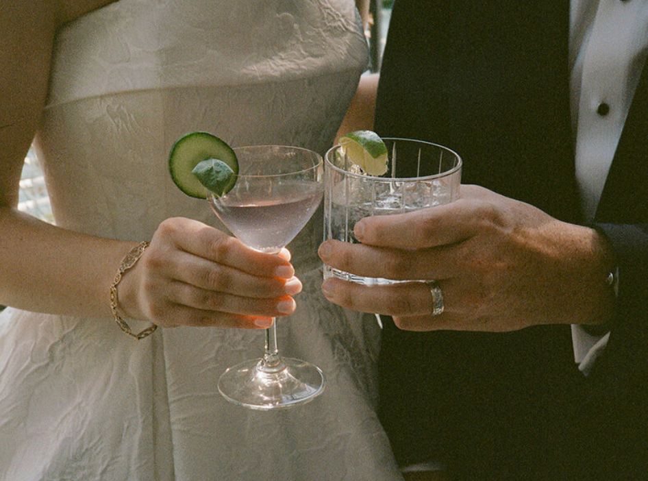 Close-up of hands holding champagne glasses at an elegant wedding celebration.
