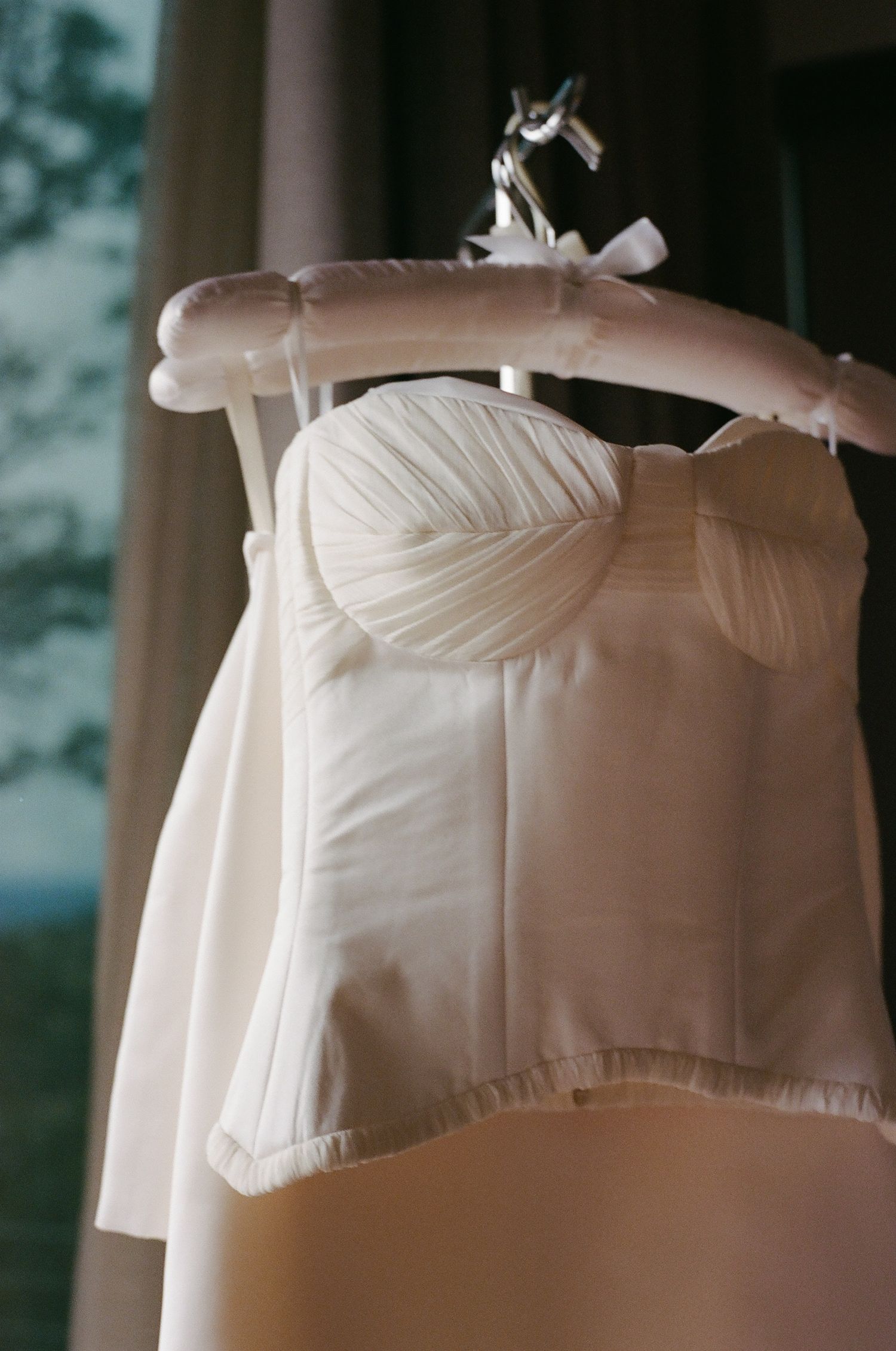 Close-up details of a white wedding dress bodice showing delicate fabric and construction.
