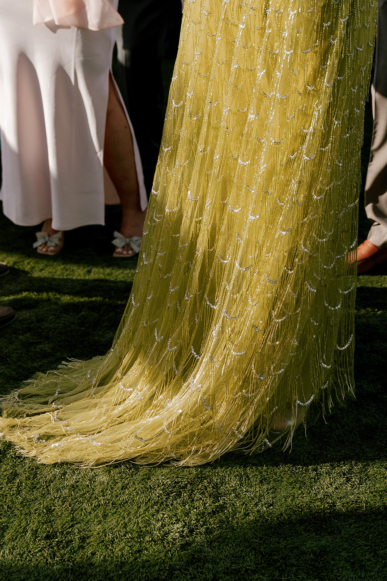 Yellow and white dress details captured in sunlight on grass.