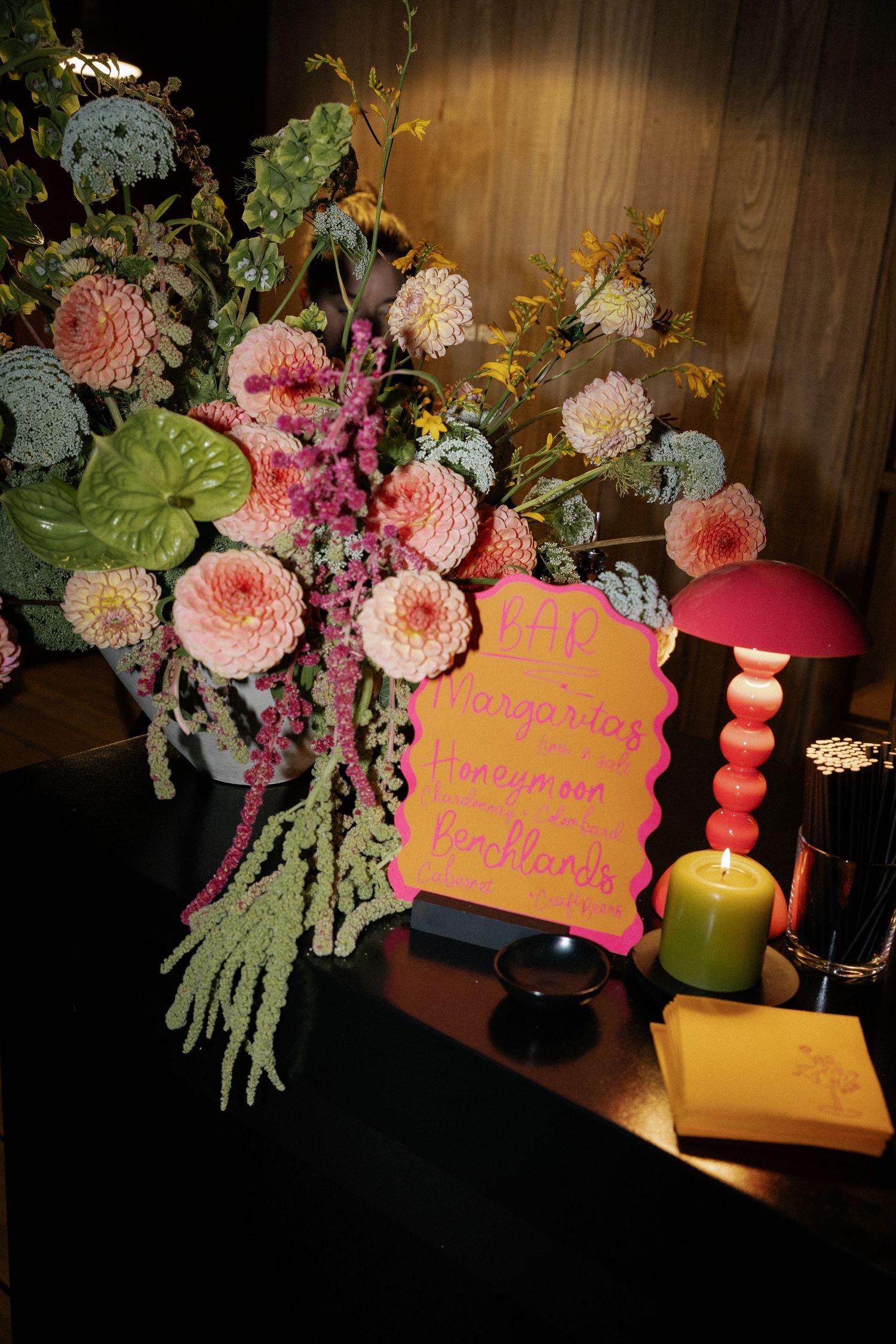 Wedding decor featuring pink floral arrangements with candles and decorative signage.