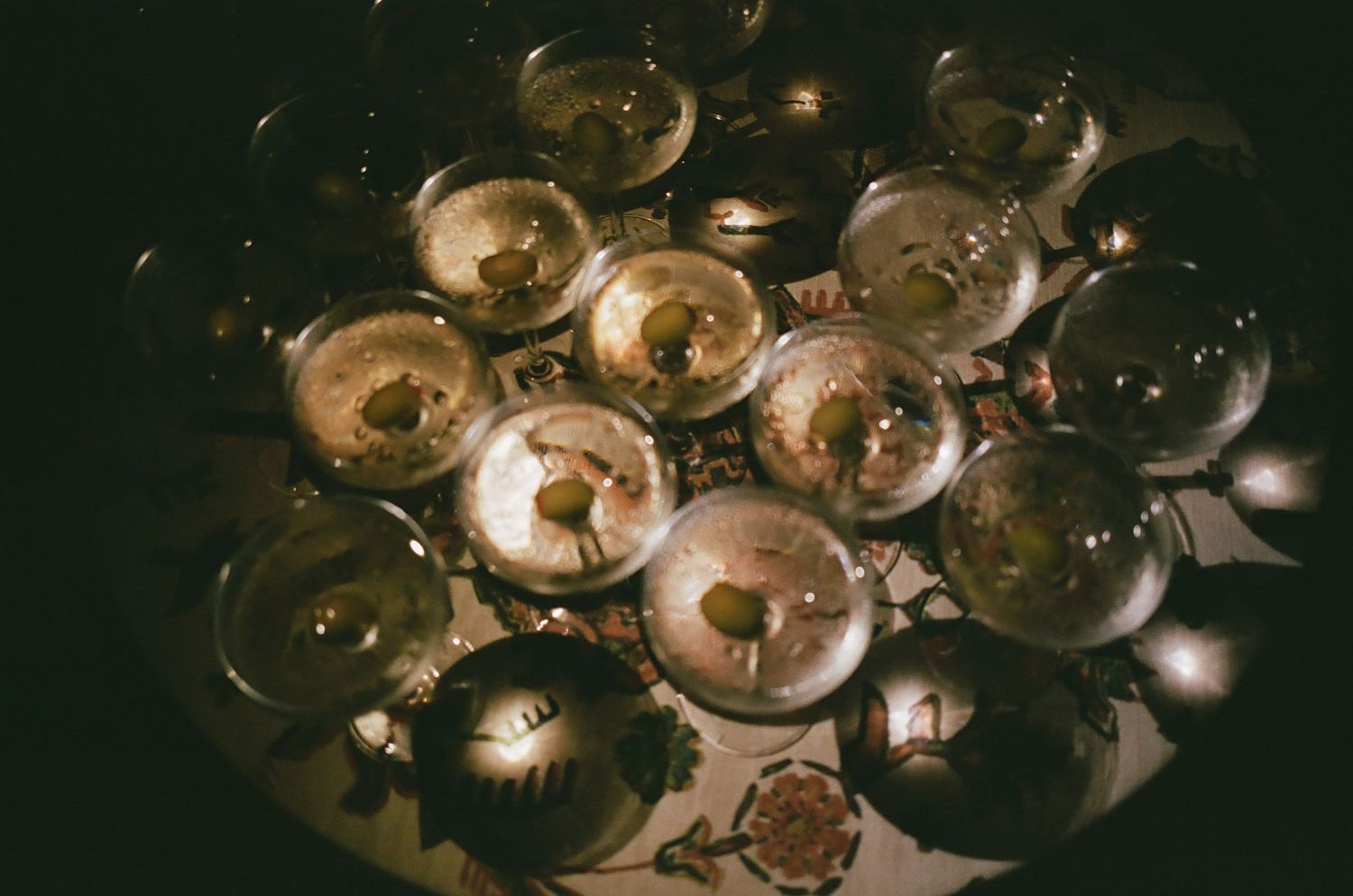 Crystal champagne glasses sparkle in dramatic lighting at an upscale event.