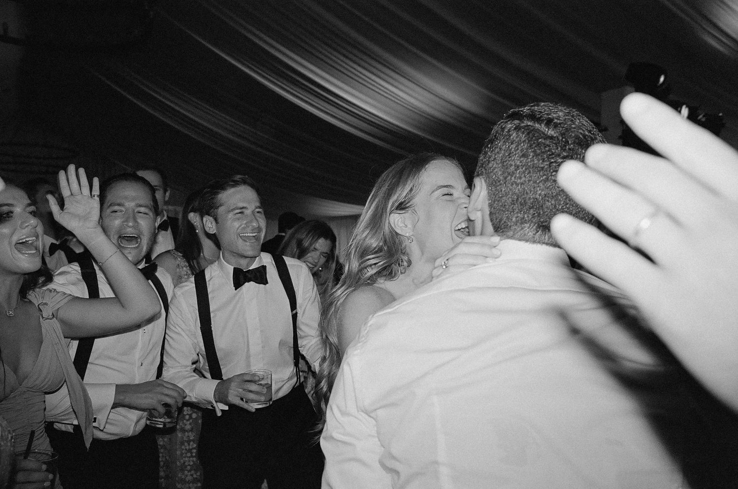 Wedding reception dance party with guests celebrating in black and white.