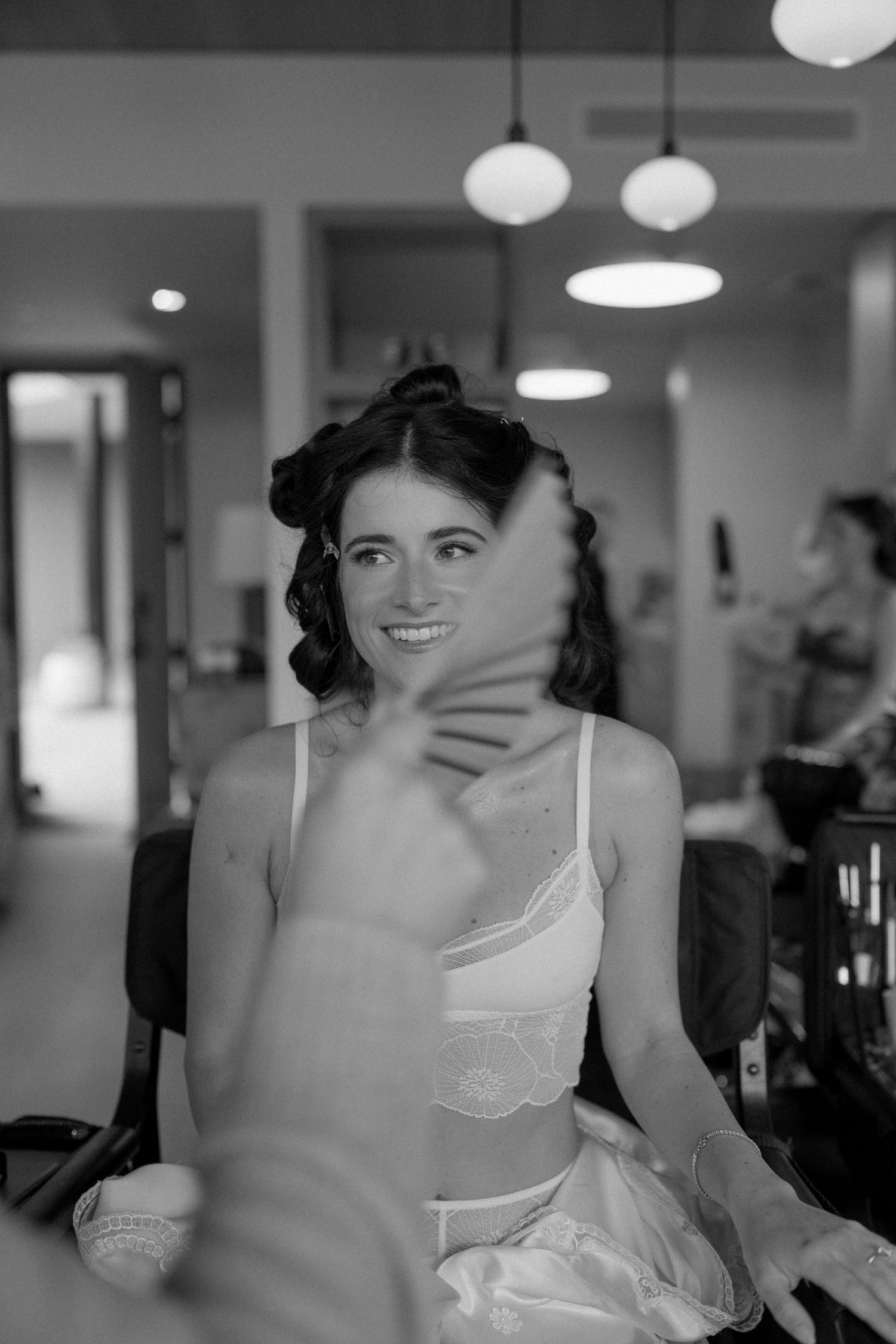 Person in a white dress smiling and laughing in a sequence of black and white photos.